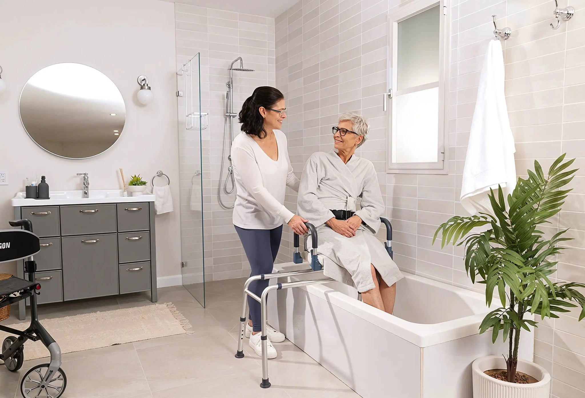 Older adult entering bathtub with caregiver support and bathroom safety equipment.