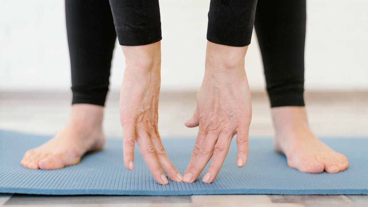 Senior performing a gentle stretch on an exercise mat as part of a peripheral neuropathy exercise therapy routine.