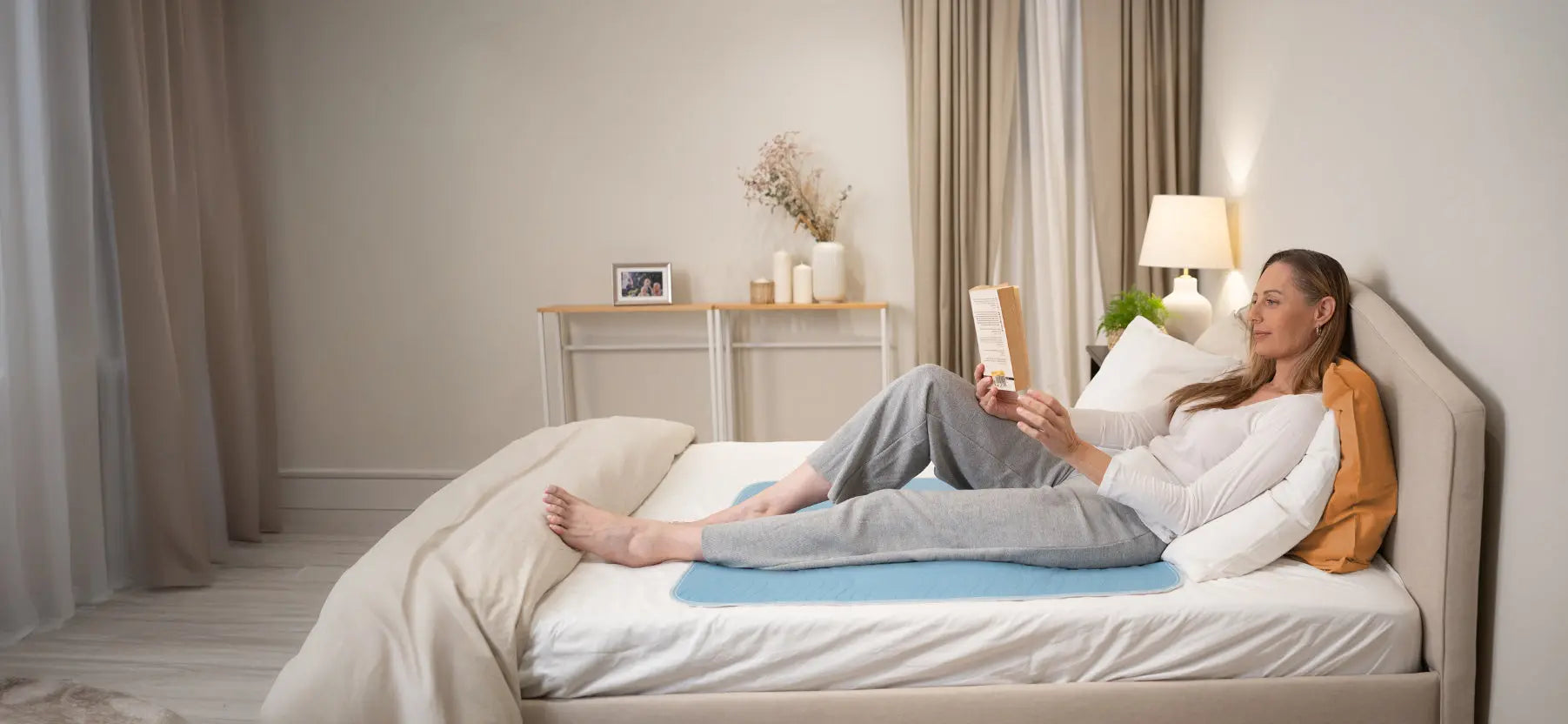 Woman relaxing on a washable bed pad designed to protect the mattress from incontinence leaks.