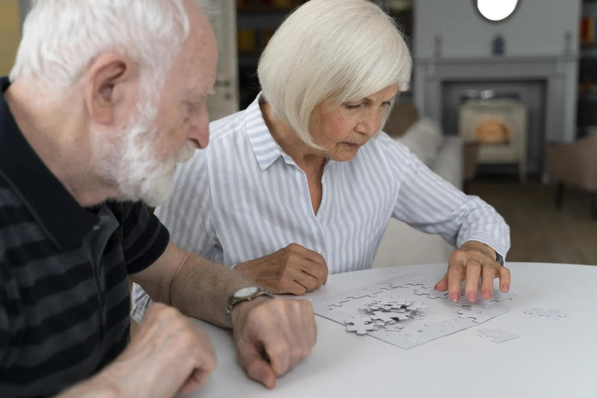 Older couple working together on a jigsaw puzzle to keep their minds active at home.