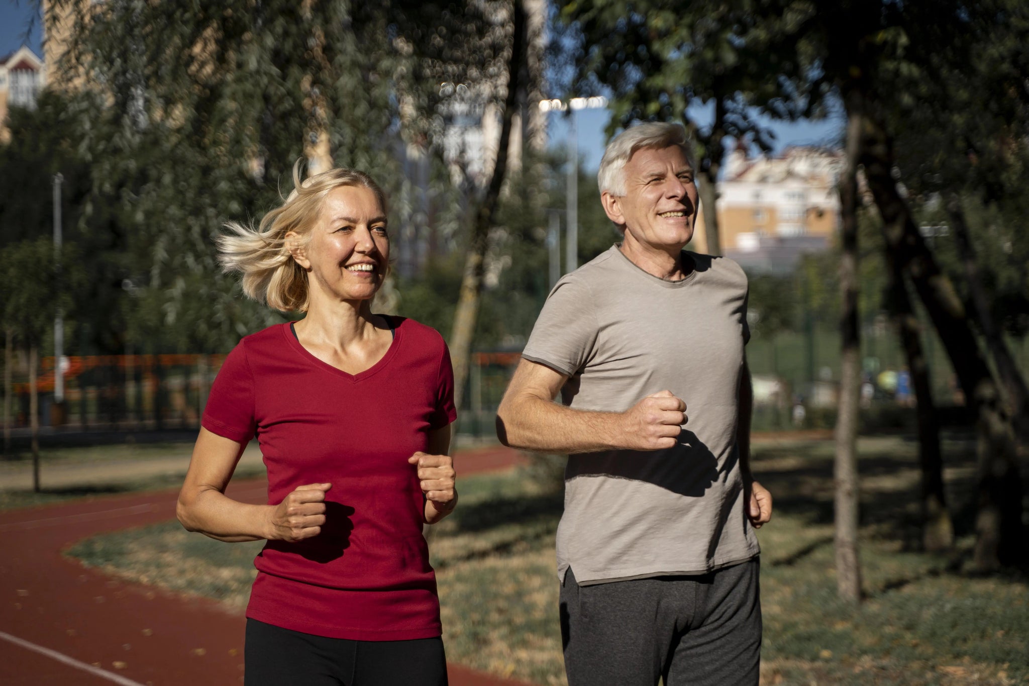 Older couple jogging outdoors as part of running for seniors.