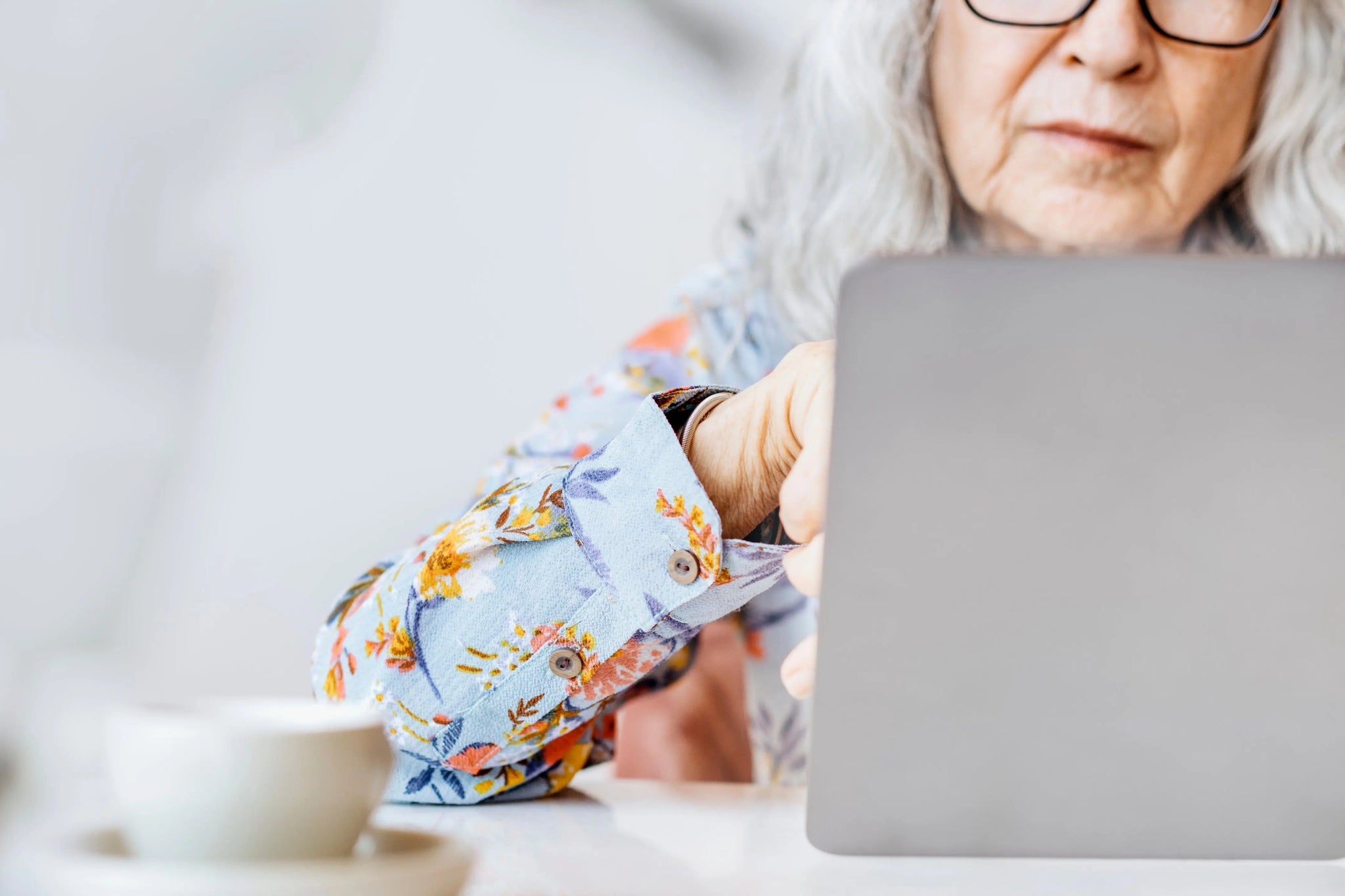 Senior using a computer at home, highlighting digital safety and senior scams.